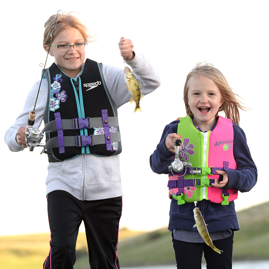 Two kids holding up fish they caught while boating