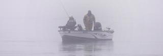 Boat with two anglers in the fog